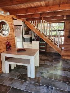 a kitchen with a wooden table in a cabin at Log Cabin- Forest, Lagoon Sea location in Hermanus