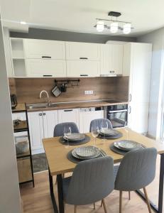 a kitchen with a table and chairs and a kitchen with white cabinets at Студио Ирма in Burgas