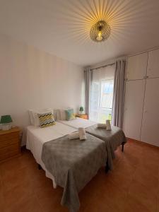 a bedroom with a large bed and a chandelier at Beach Relax Apartment in Porto Santo