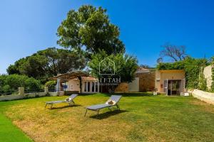 two chairs sitting in the grass in front of a building at Charming villa with pool and unobstructed view in Tangier