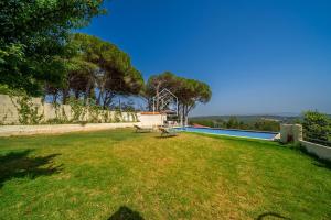 a swimming pool with a bench in the grass at Charming villa with pool and unobstructed view in Tangier