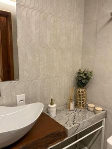 a bathroom with a white sink and a mirror at NATU Visconde de Mauá in Itatiaia
