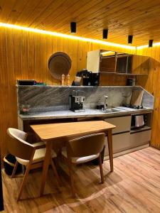 a kitchen with a wooden table and a counter top at NATU Visconde de Mauá in Itatiaia