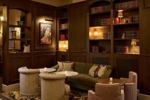 a living room with a couch and chairs and bookshelves at The Hoxton, Dublin in Dublin