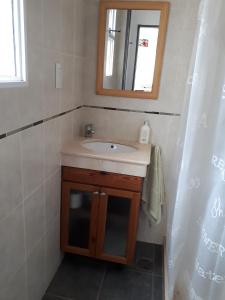 a bathroom with a sink and a mirror at Alfonsina 2 in Colón +6 photos