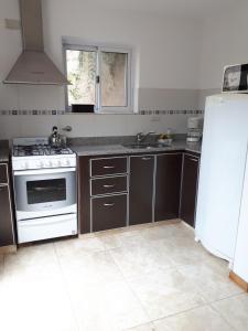 a kitchen with a stove and a white refrigerator at Alfonsina 2 in Colón