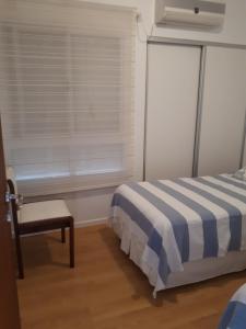 a bedroom with a bed and a chair and a window at Alfonsina 2 in Colón