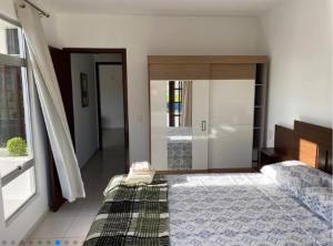a bedroom with a bed and a large window at RCM Vilas - Casa confortável 1 in Joinville