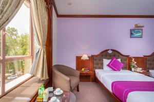 Postel nebo postele na pokoji v ubytování TTC Hotel - Da Lat