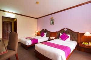 Postel nebo postele na pokoji v ubytování TTC Hotel - Da Lat