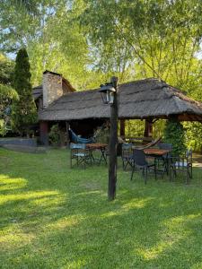 a pavilion with a table and chairs in the grass at Rio Manso Tigre in Tigre