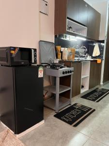 a small kitchen with a microwave and a refrigerator at Ems Haven Apartment in Ongata Rongai 