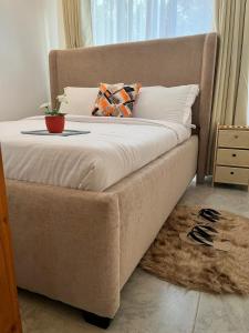 a large bed with a pillow and a plant on it at Ems Haven Apartment in Ongata Rongai 
