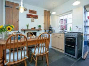 a kitchen with a wooden table and chairs and an oven at Tillerman Cottage Appledore Devon in Appledore