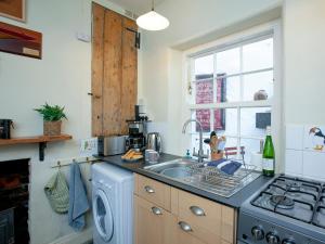a kitchen with a sink and a washing machine at Tillerman Cottage Appledore Devon in Appledore