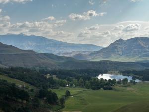a view of a valley with a lake and mountains at The Keep Cottage in Underberg