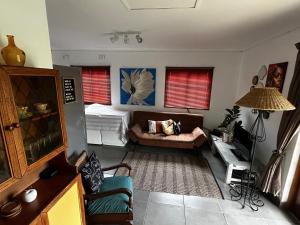 a living room with a couch and a table at The Keep Cottage in Underberg