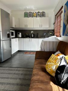 a living room with a couch and a kitchen at The Keep Cottage in Underberg