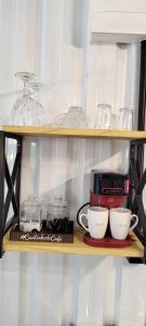a shelf with two cups and a coffee maker at Refúgio Aconchegante in São Sebastião