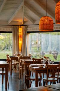 a restaurant with wooden tables and chairs and a large window at Hosteria El Puma in El Chalten