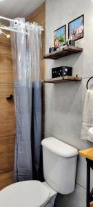 a bathroom with a toilet and a shower curtain at Refúgio Aconchegante in São Sebastião +23 photos