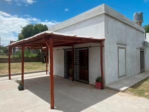 a small white building with a wooden roof at La Esquina en el Rio in Paraná