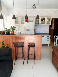 a kitchen with a counter and two bar stools at Riviera engenharia in Campo Grande