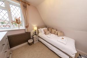 a small bedroom with a bed and a window at Rectory Cottage near Paultons park & New Forest in Ower