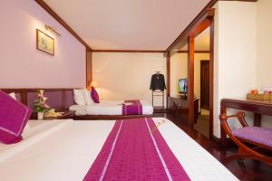 Postel nebo postele na pokoji v ubytování TTC Hotel - Da Lat