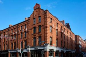 a large red brick building on a city street at The Hoxton, Dublin in Dublin