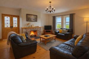 a living room with two couches and a fireplace at 4 Bedroom House By Travel Lets Holiday Homes Carrigart With Sea View in Carrigart
