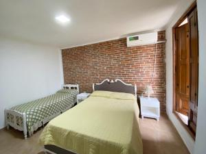 a bedroom with a bed and a brick wall at La Esquina en el Rio in Paraná