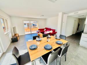 a dining room with a wooden table and chairs at Brand-New Eiger View 3BR Apartment - Premium Location - Free Parking - Terrace in Grindelwald