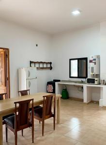 a dining room with a table and chairs and a refrigerator at La Esquina en el Rio in Paraná