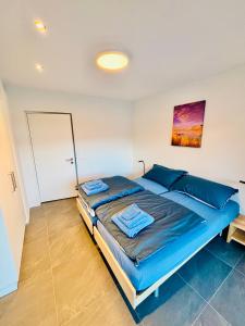 a bedroom with a large bed with blue pillows at Brand-New Eiger View 3BR Apartment - Premium Location - Free Parking - Terrace in Grindelwald