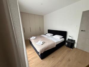 a bedroom with a bed with two towels on it at Duży Apartament 3 pokoje Park City in Ostrów Wielkopolski