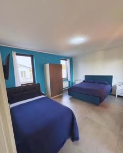 a bedroom with two beds and blue walls at GC Petit Palais in Gallarate