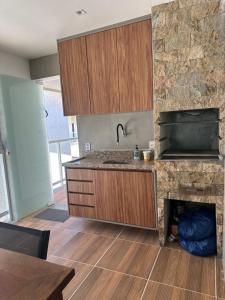 a kitchen with wooden cabinets and a counter top at Village com 2 suites com ar a 300mts da praia e do rio in Mata de Sao Joao +25 photos