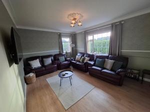 a living room with leather couches and a table at Fjell2Sea in Newcastle