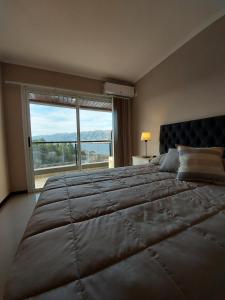 a bedroom with a large bed with a large window at Veneto Village in Villa Parque Siquiman +13 photos