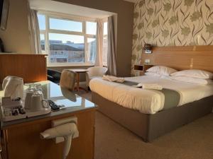 a hotel room with a bed and a window at The Avenue Hotel in Grantham