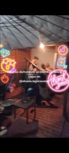 a group of people standing in a room with neon signs at Cabañas El Oasis Laguna Verde in Laguna Verde