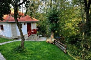 a yard with a bench and a house at Šumarak Weekend House in Arandelovac