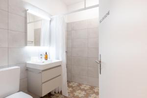 a white bathroom with a sink and a toilet at Bed and Breakfast Kloster Frienisberg in Seedorf