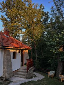 a white building with a red roof and stairs at Šumarak Weekend House in Arandelovac