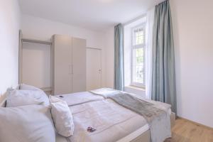 a white bedroom with a bed and a window at Bed and Breakfast Kloster Frienisberg in Seedorf