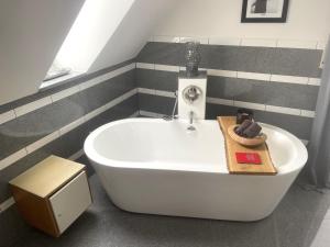 a white bath tub in a bathroom with striped walls at Ferienhaus am Dürrbachtal in Unterleinleiter