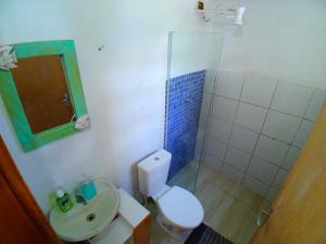 a bathroom with a toilet and a sink and a mirror at Camburi Chalet - por do sol in São Sebastião