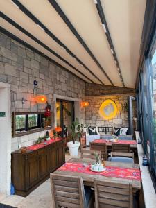a patio with tables and chairs and a stone wall at LUTA Urla in Urla