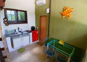 a small kitchen with a sink and a table and chairs at Camburi Chalet - por do sol in São Sebastião